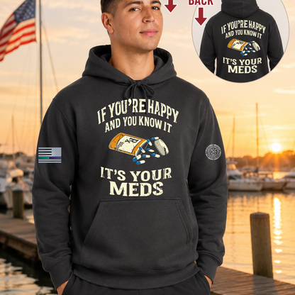 Man wearing a black hoodie with a humorous message by a dock with an American flag.