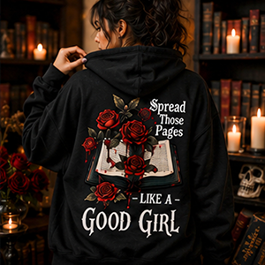 Person wearing a black hoodie with floral design and text in a cozy, candlelit room.